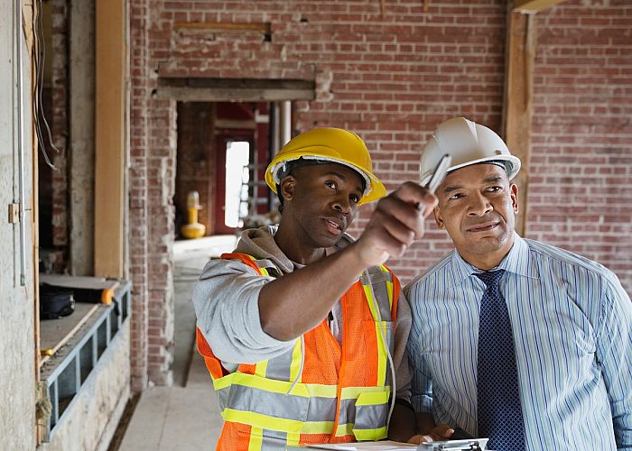 two construction workers pointing